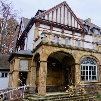 Eine historische, langsam verfallende Villa in Marienburg von außen.