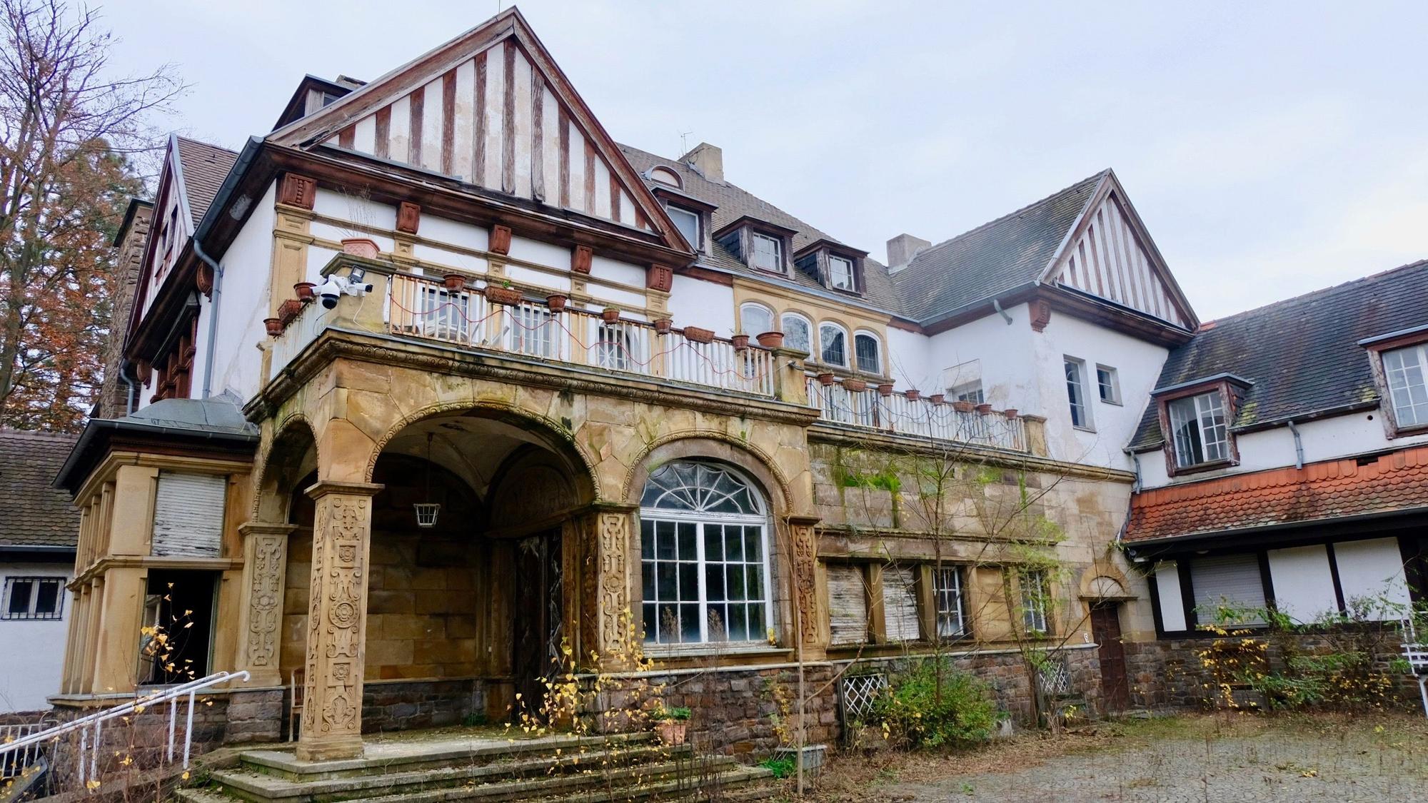 Eine historische, langsam verfallende Villa in Marienburg von außen.