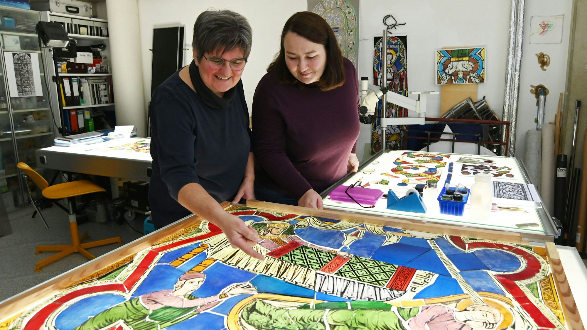 19.12.2024 Köln. Gerlinde Möhrle (Brille) und Sandra Williger restaurieren Fenster von St. Kunibert. Foto: Alexander Schwaiger