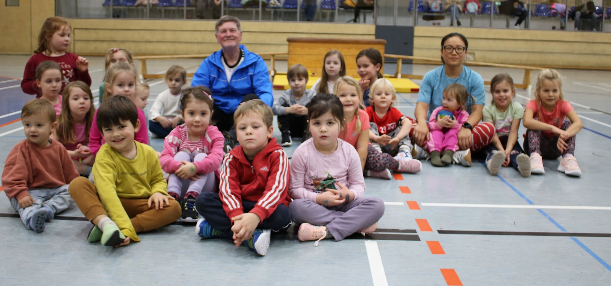 Zwischen den jüngsten Leichtathleten des Vereins sitzen Klaus Heinen und Ping Ding.