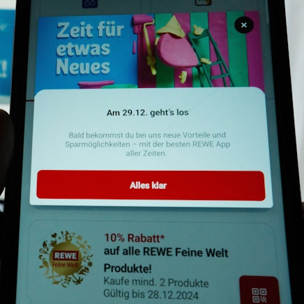Auf einem Smartphone-Bildschirm ist eine Seite aus einer App des Handelskonzerns Rewe dargestellt.