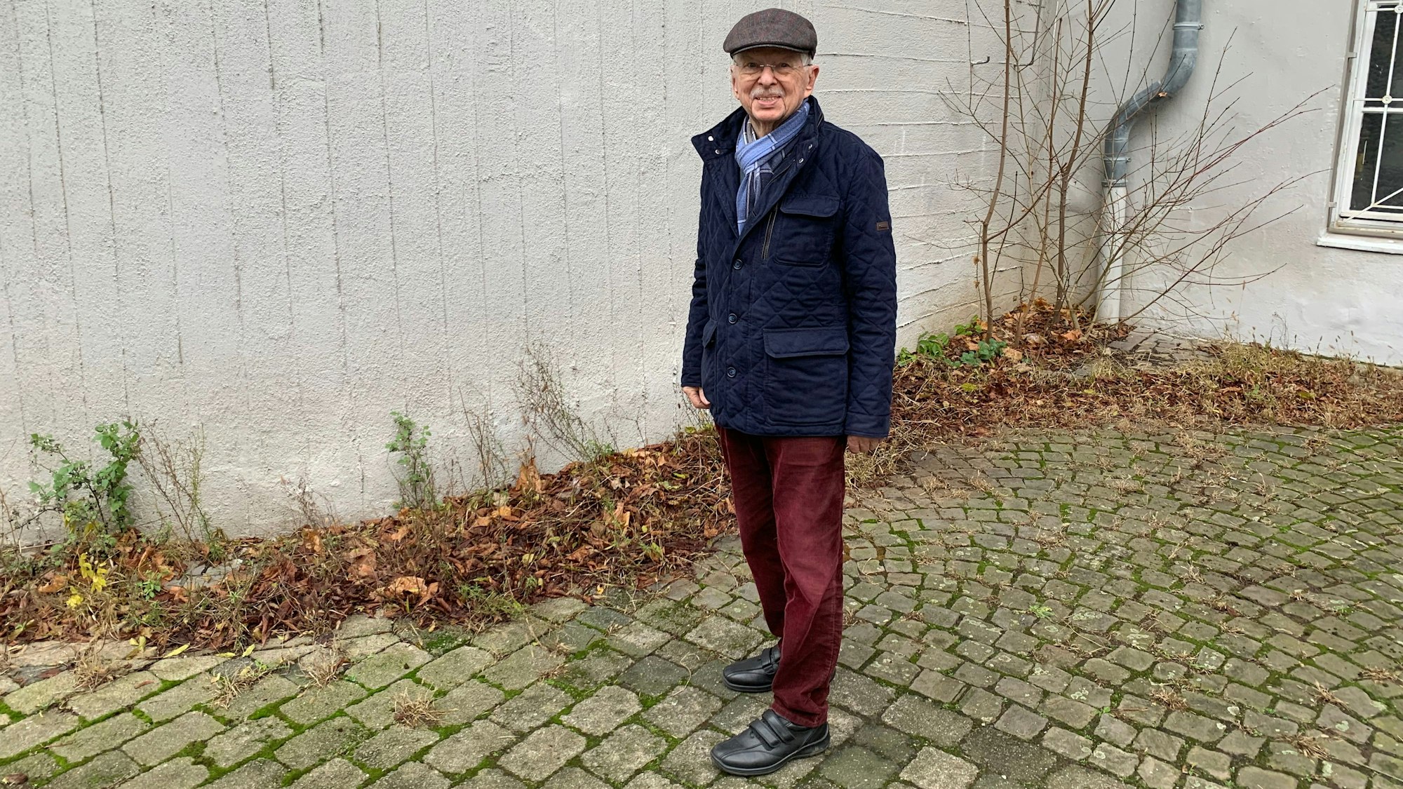 Ein Mann steht vor einem Gebäude.