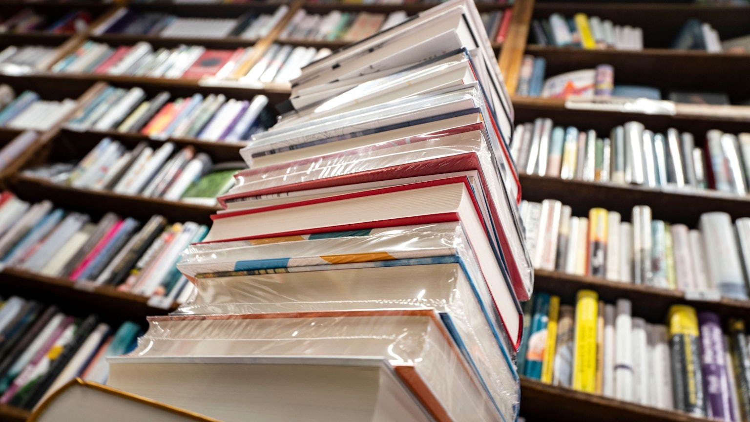 Ein Stapel neuer Bücher liegt auf einem Verkaufstisch in einer Buchhandlung.