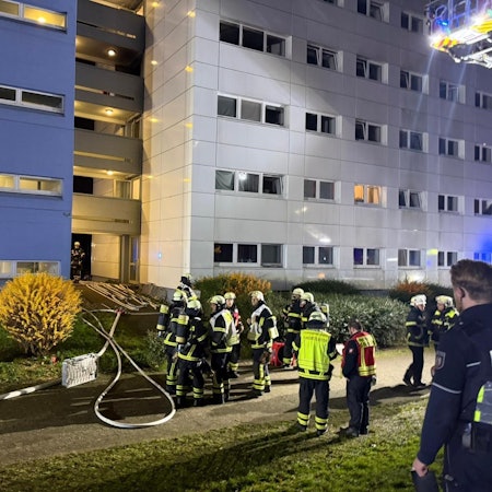 Einsatzkräfte stehen in Hürth vor einem Wohnhaus.
