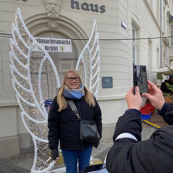 Zu sehen ist Heidi Feuersänger, die sich vor Engelsflügeln fotografieren lässt.