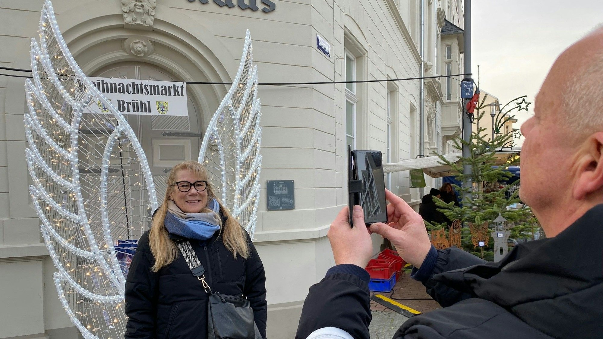 Zu sehen ist Heidi Feuersänger, die sich vor Engelsflügeln fotografieren lässt.