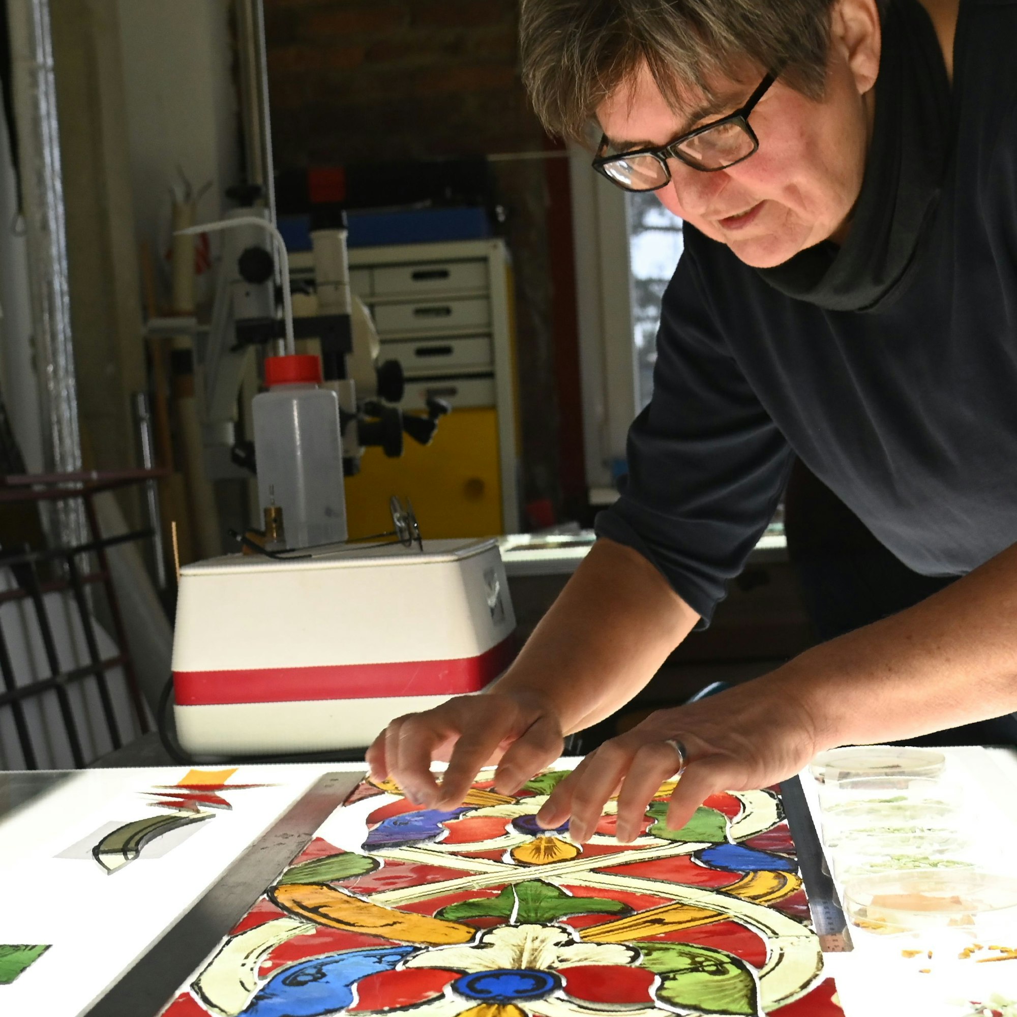 19.12.2024 Köln. Gerlinde Möhrle (Brille) und Sandra Williger restaurieren Fenster von St. Kunibert. Foto: Alexander Schwaiger