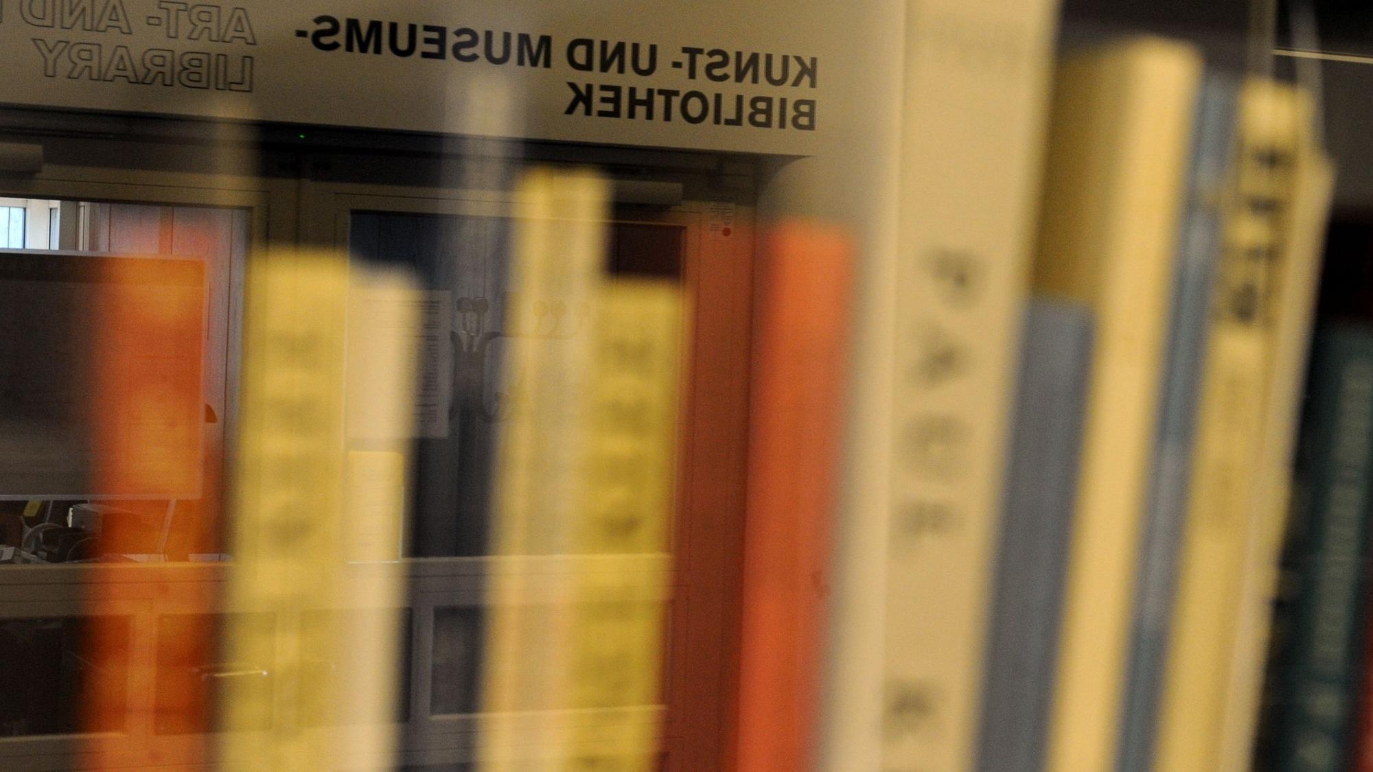 Bücher stehen in einem Regal.