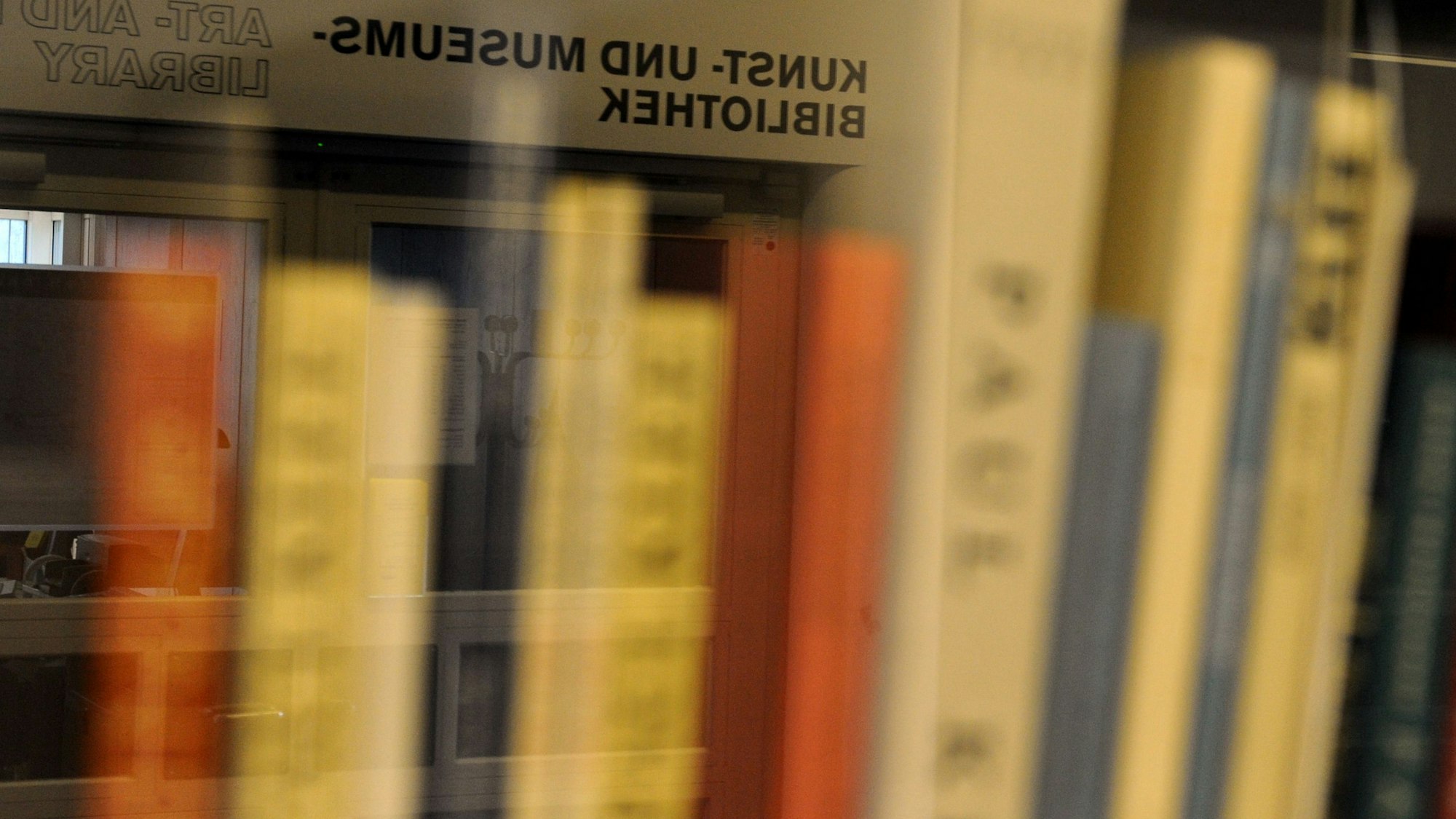 Bücher stehen in einem Regal.