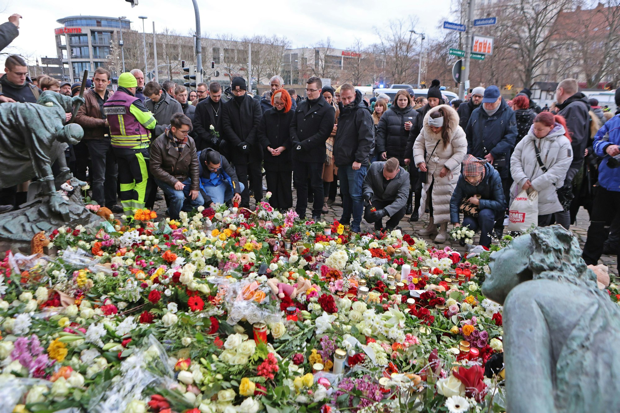21.12.2024, Sachsen-Anhalt, Magdeburg: Menschen legen am offiziellen Trauerort vor der Johanniskirche in Magdeburg Blumen und Kerzen ab. Auf dem Weihnachtsmarkt in Magdeburg ist ein Autofahrer in eine Menschengruppe gefahren. Foto: Matthias Bein/dpa +++ dpa-Bildfunk +++