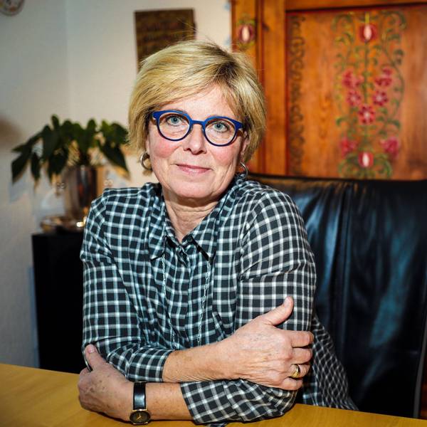 Verena Welschof sitzt zuhause an einem Esstisch und lächelt in die Kamera. Sie sieht frisch und gut aus.