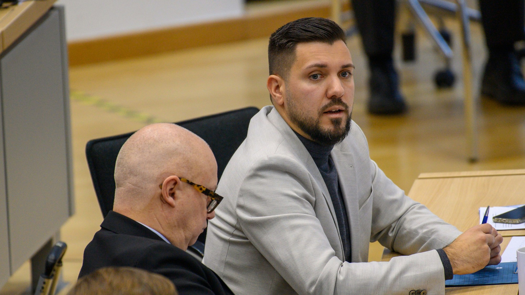 20.11.2024, Sachsen-Anhalt, Magdeburg: Tobias Rausch (r, AfD) sitzt im Plenarsaal des Landtages von Sachsen-Anhalt an seinem Abgeordnetenplatz. Dort kamen die Abgeordneten am Morgen zur 77. Sitzung zusammen. Auf Antrag der CDU-Fraktion wird es nach der Regierungsbefragung eine Aktuelle Debatte zum Thema "Indexmodell für Rundfunkbeitrag ablehnen!" geben. (zu dpa: «AfD scheitert im Parlament mit Ukraine-Antrag») Foto: Klaus-Dietmar Gabbert/dpa +++ dpa-Bildfunk +++
