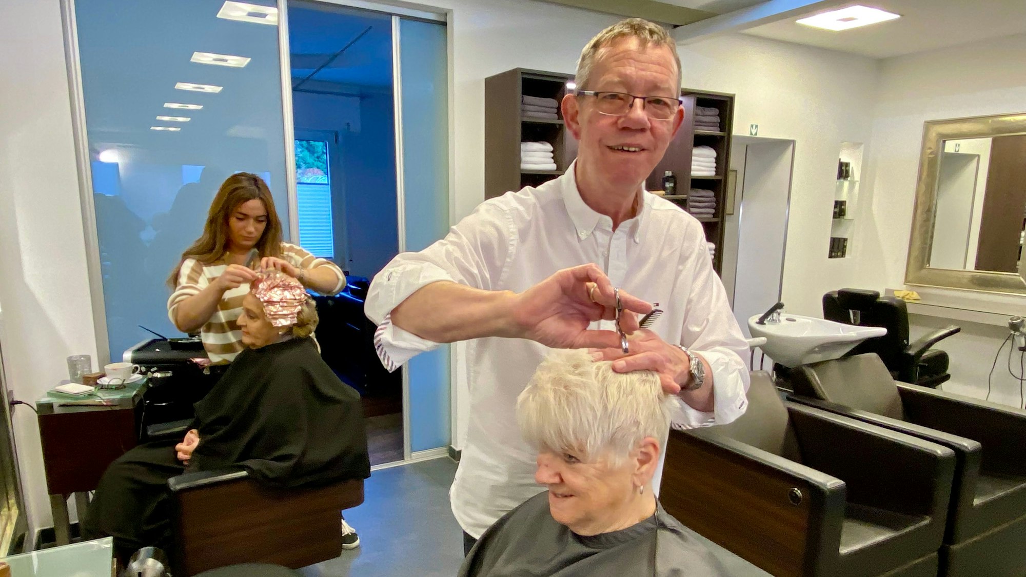 Zu sehen ist ein Friseur in einem Salon.