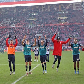 Die Spieler des 1.FC Kölns bejubeln den Sieg vor der Fankurve.