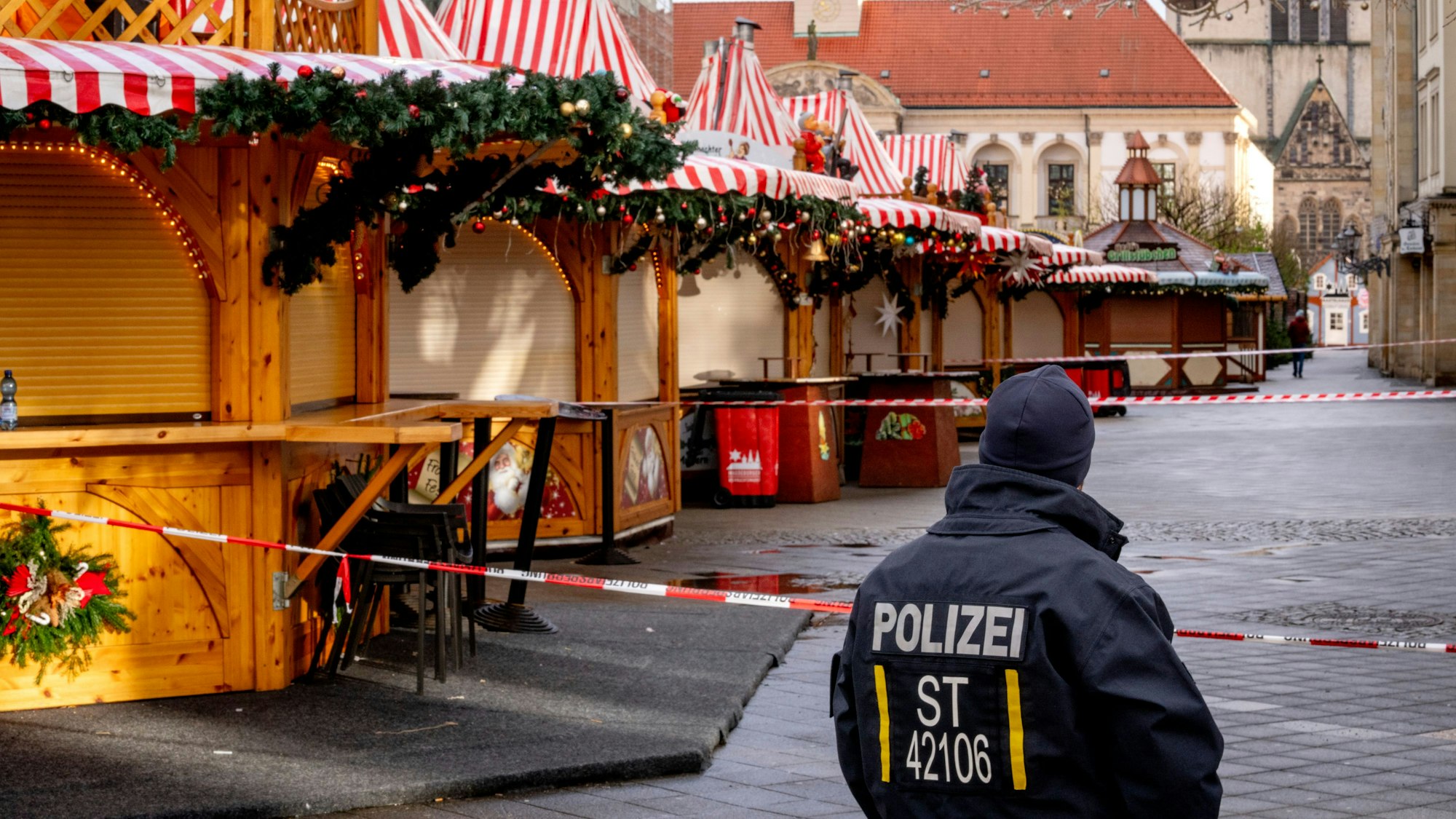 Ein Polizist steht vor dem Weihnachtsmarkt in Magdeburg, auf dem am Freitag ein Auto in die Menschenmenge raste.