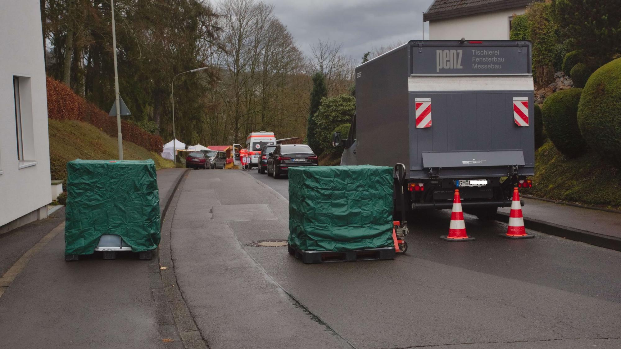 Quadratische Flüssigkeitscontainer versperren die Durchfahrt oberhalb des Burghauses.