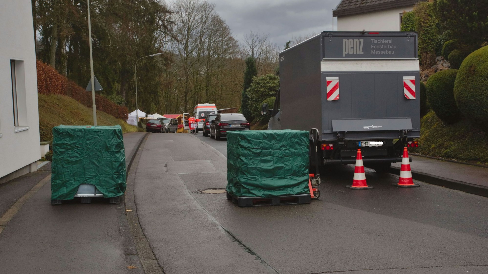 Quadratische Flüssigkeitscontainer versperren die Durchfahrt oberhalb des Burghauses.
