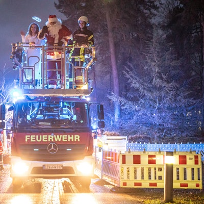 Bunt beleuchtete Einsatzfahrzeuge fuhren in Kolonne durch den Park des Klinikums in Leverkusen.