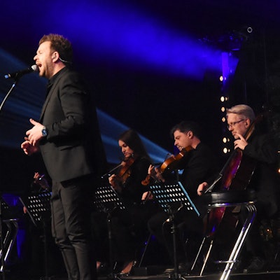 Ein Sänger und Streicher auf einer Bühne.
