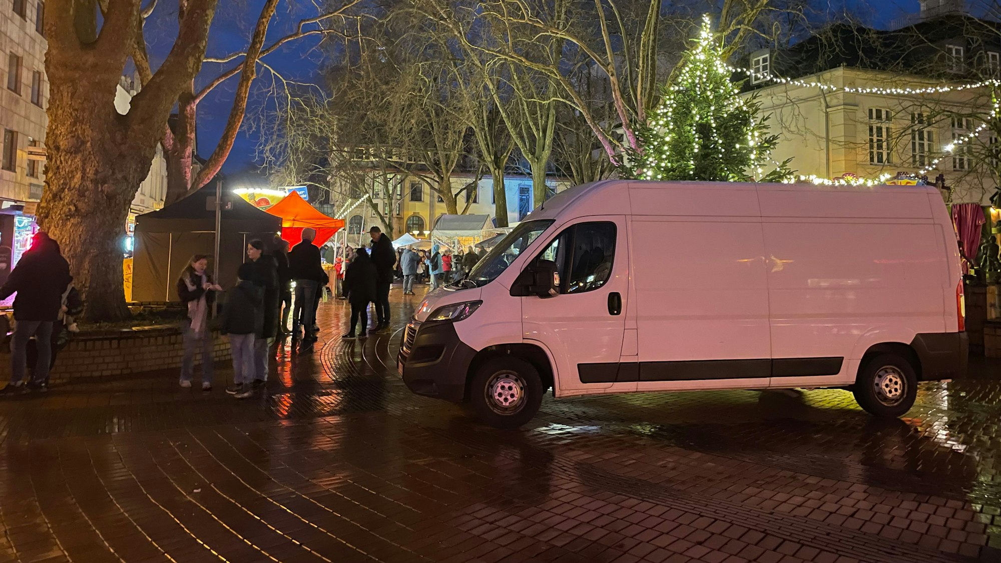 Auf dem Foto ist ein weißer Transporter zu sehen, der die Zufahrt zum Weihnachtsmarkt in Frechen blockieren soll.