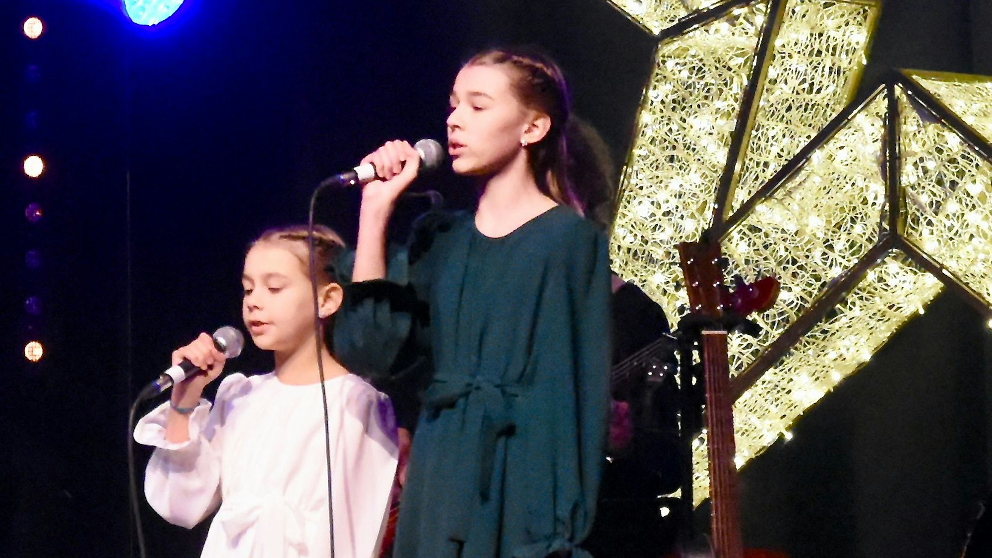 Zwei junge Sängerinnen vor einem Stern.