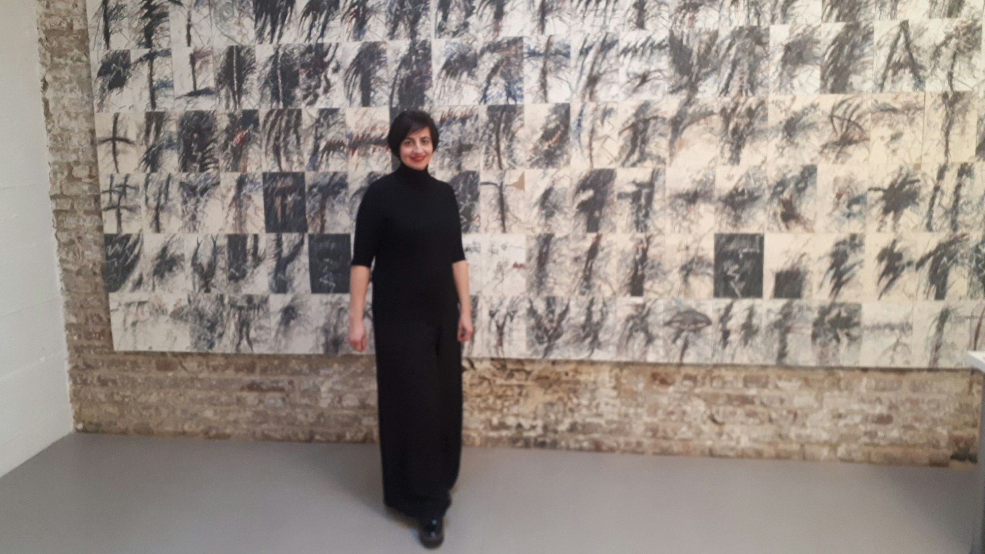 Janine Koppelmann, die Tochter der Atelier-Gründerin, vor der 140-teiligen Zeichnungsserie von Peter Gilles, entstanden im Eindruck des Attentats auf Ronald Reagan 1981.