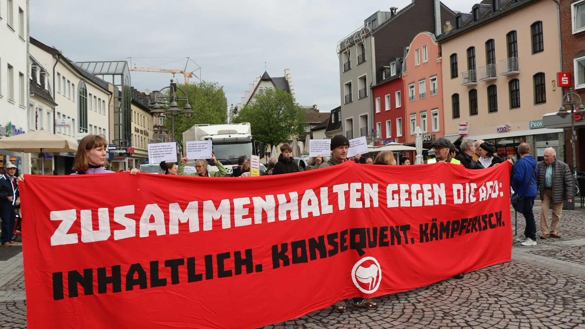 Zu sehen sind Demonstranten, die ein rotes Banner tragen.