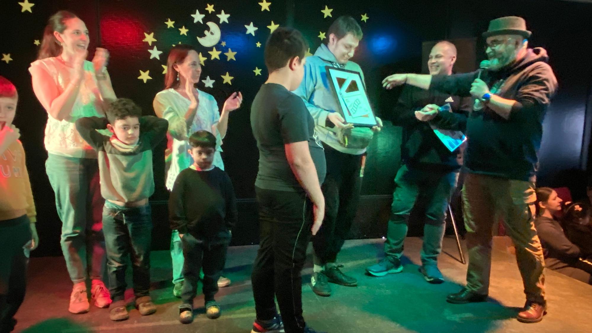 Georg Peters (rechts) und Heiko Bleike vom Porzer Klimatreff überreichten den Preis für das Mut machende Video im Rahmen der Talent-Show der Pestalozzischule an Moderator Severin.