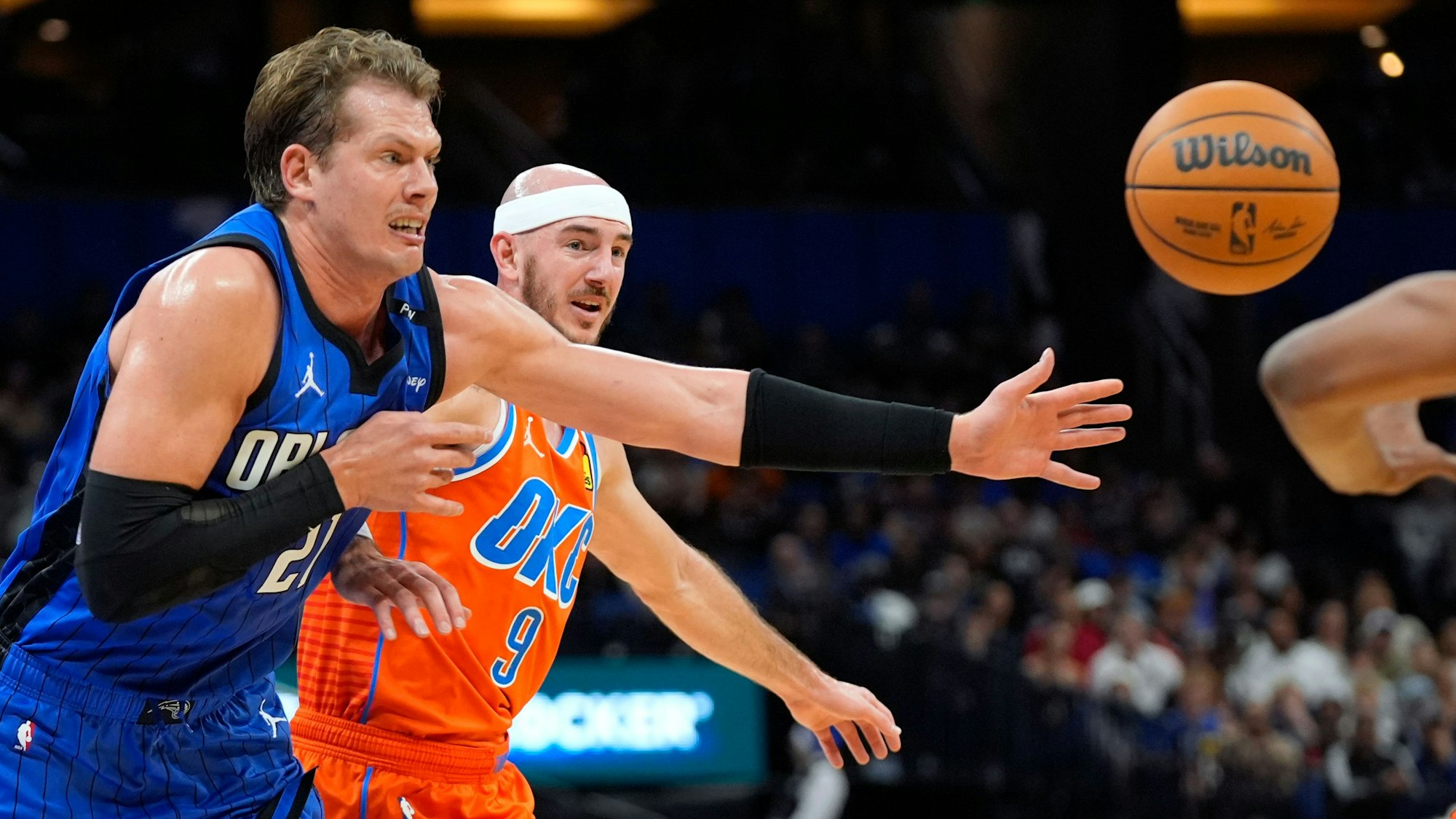 Moritz Wagner (l), Center der Orlando Magic, läuft während der ersten Halbzeit vor Oklahoma City Thunder-Guard Alex Caruso (9) dem Ball hinterher.