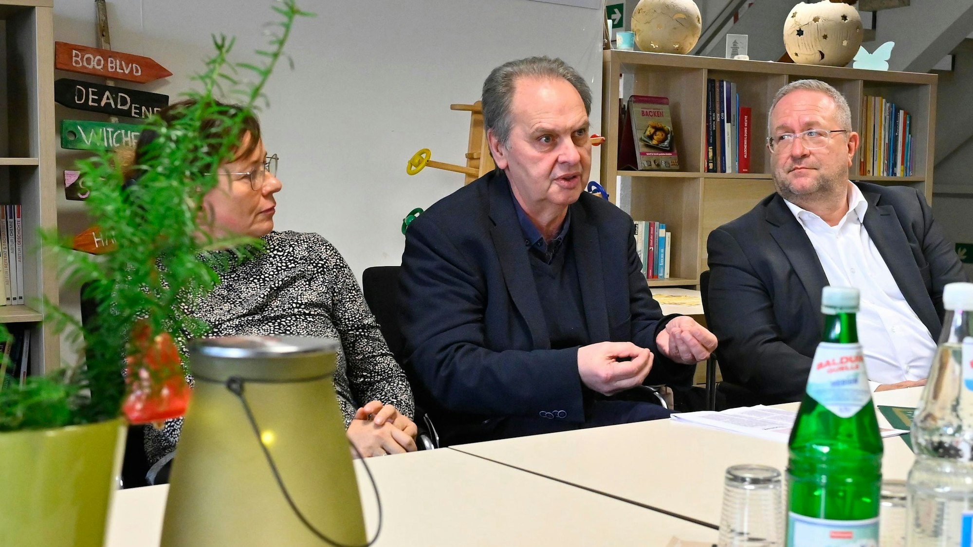 Ein Mann sitzt an einem Tisch und erklärt.