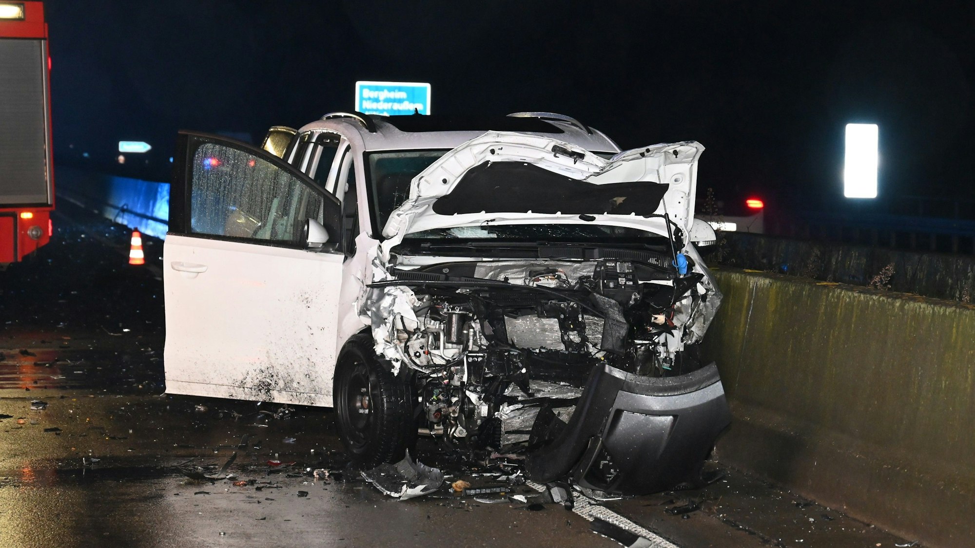 Ein weißes, schwer zerstörtes Auto steht auf der Fahrbahn.