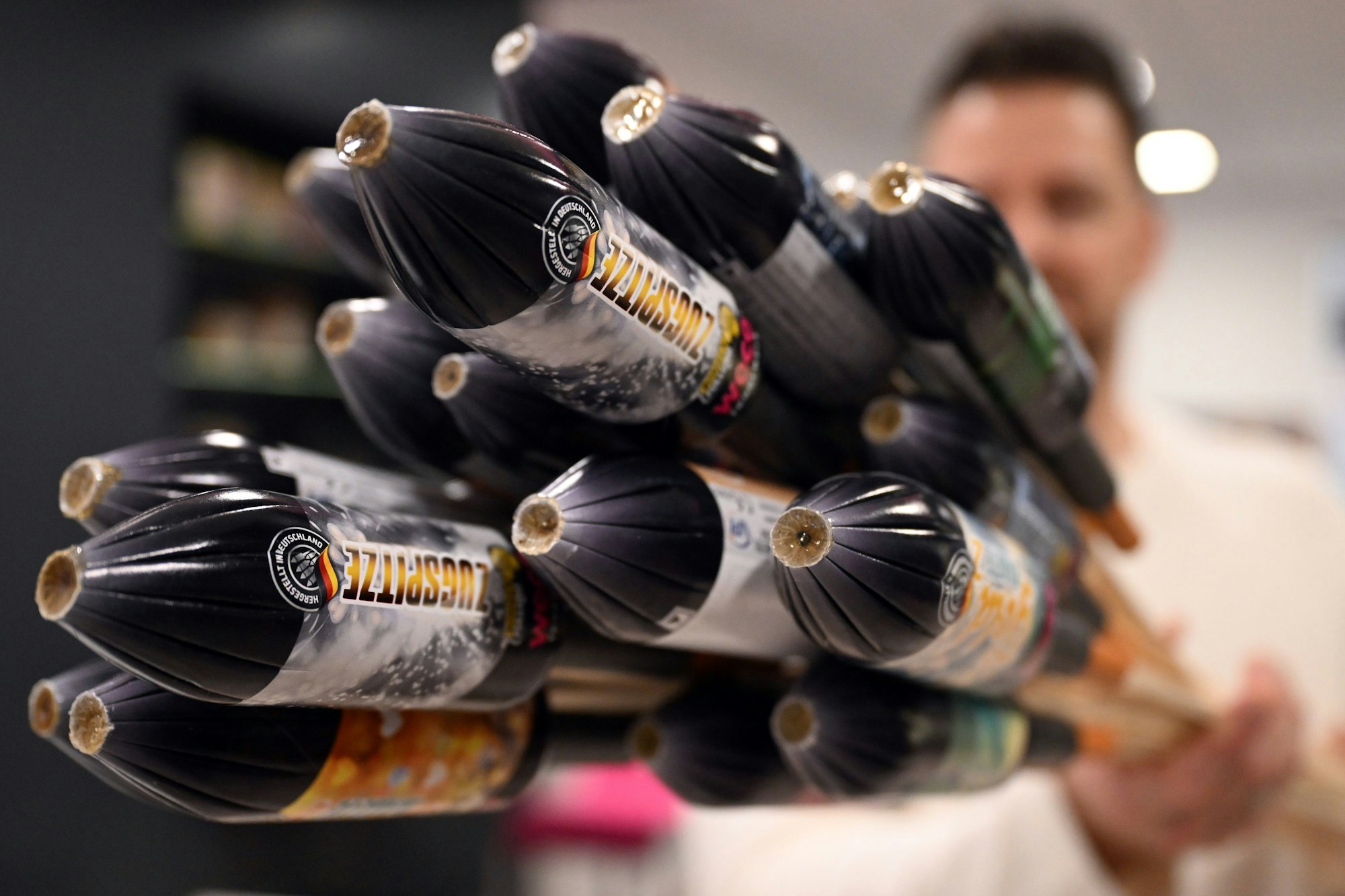 ARCHIV - 19.12.2023, Nordrhein-Westfalen, Eitorf: Ein Mitarbeiter hält im Showroom der Feuerwerksfirma Weco Silvesterraketen. Weco meldet hohe Verkaufszahlen. (zu dpa: «Feuerwerk trotz höherer Preise «beliebt wie nie»») Foto: Federico Gambarini/dpa +++ dpa-Bildfunk +++