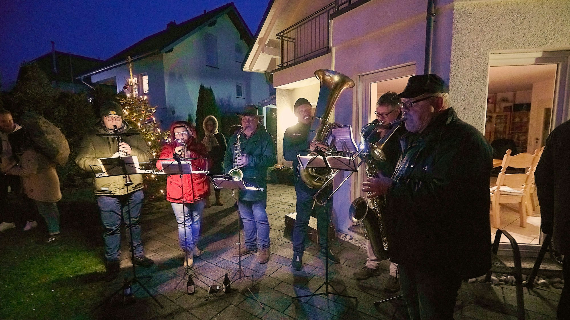Sechs Musiker spielen auf der Terrasse eines Hauses.