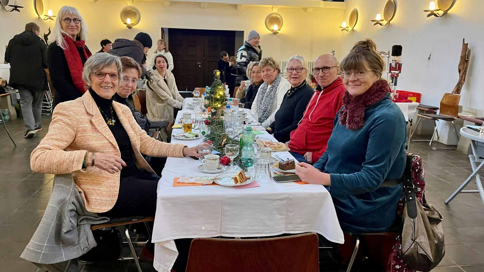 Menschen sitzen an einer langen Tafel.
