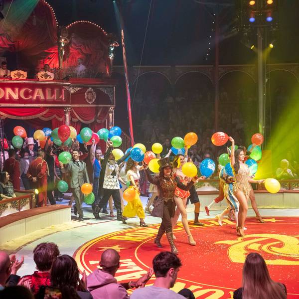 Artisten laufen zum Schluss-Applaus mit Luftballons in die Manege.