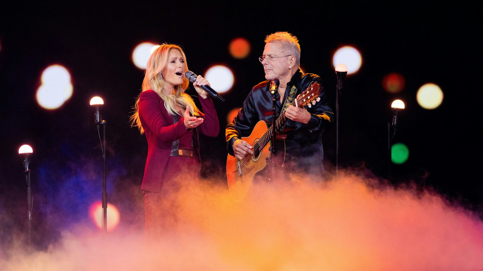 Helene Fischer am Mikrofon und Reinhard Mey an der Gitarre stehen im Bühnennebel.