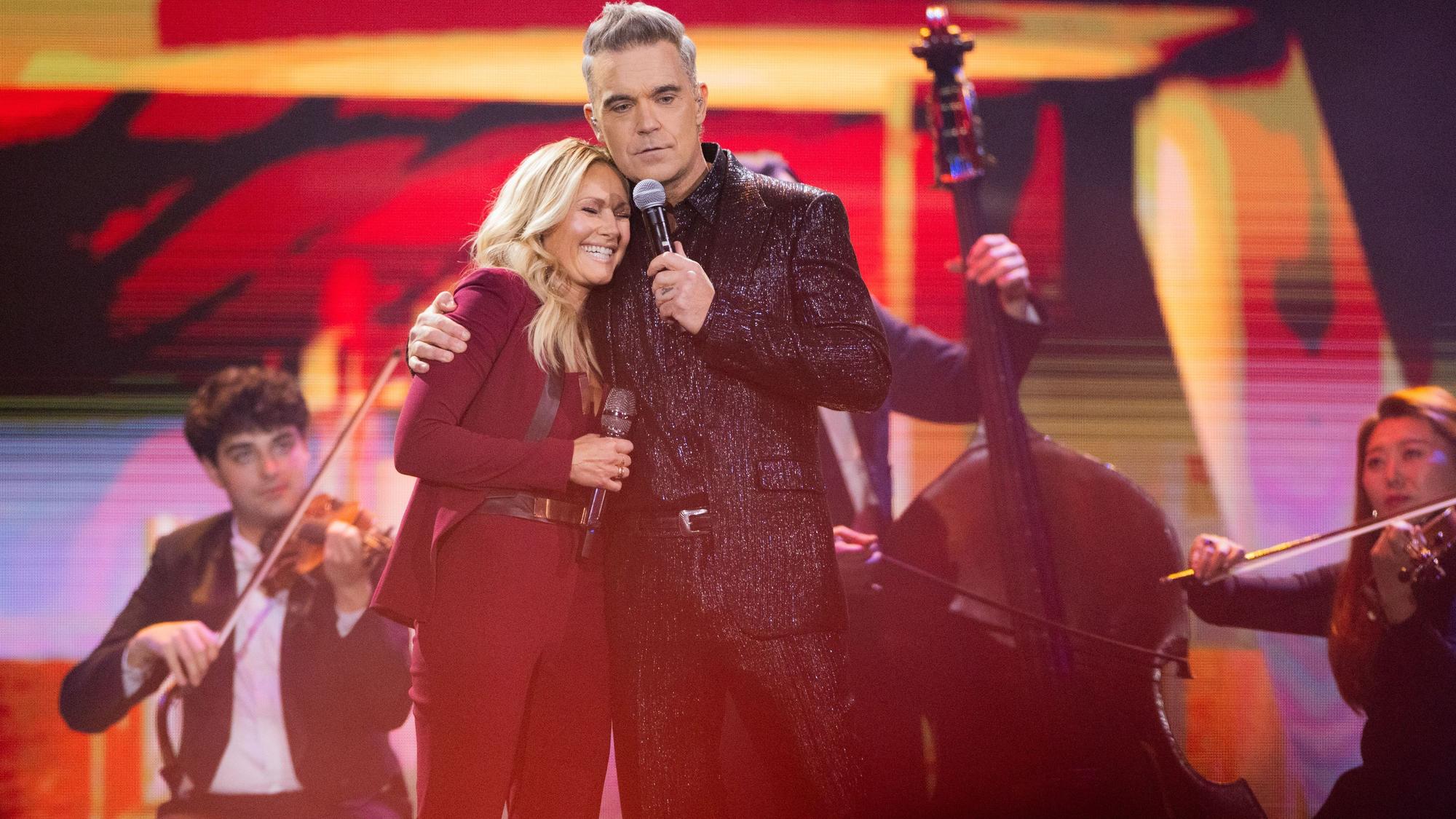 Helene Fischer und der britische Sänger Robbie Williams stehen bei der Aufzeichnung der Helene-Fischer-Show auf der Bühne.