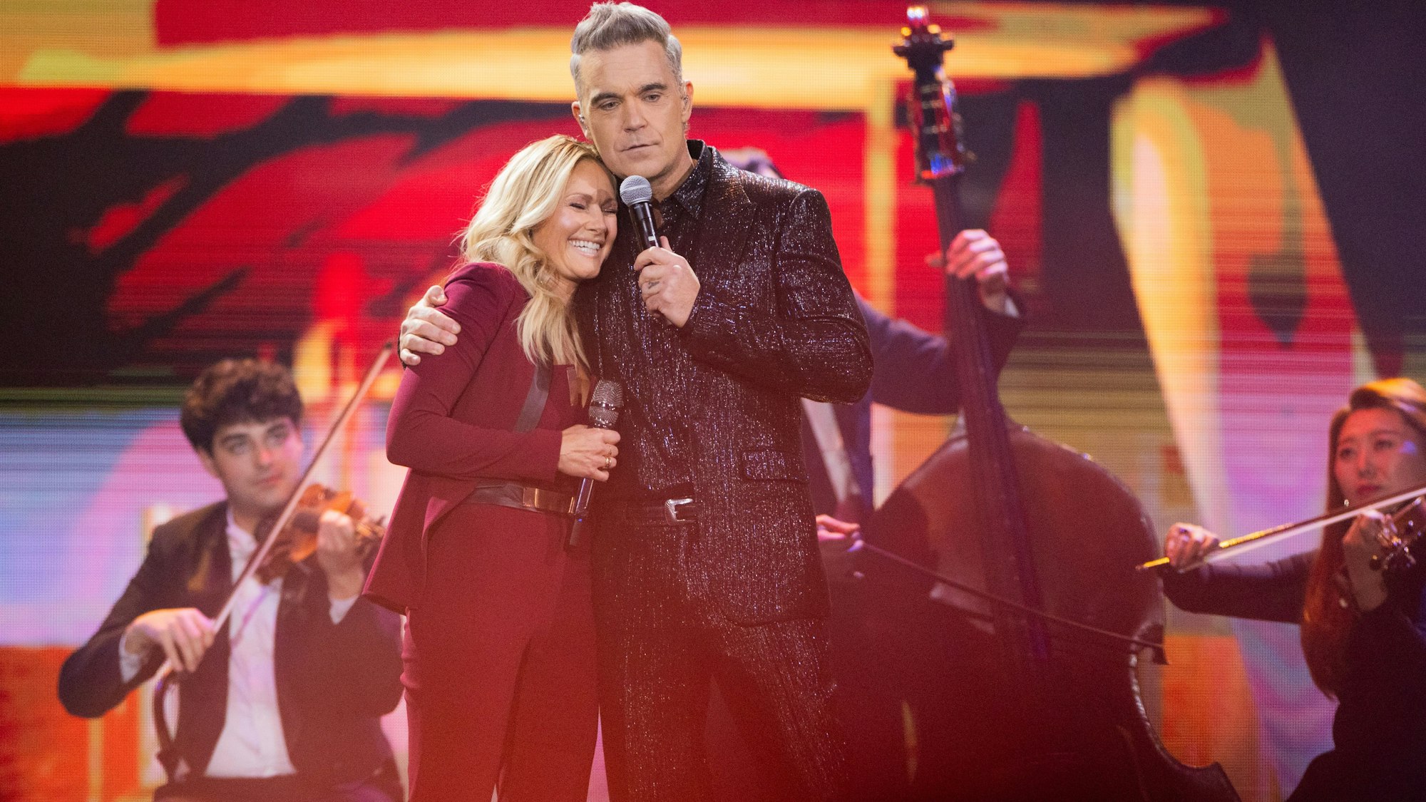 Helene Fischer und der britische Sänger Robbie Williams stehen bei der Aufzeichnung der Helene-Fischer-Show auf der Bühne.