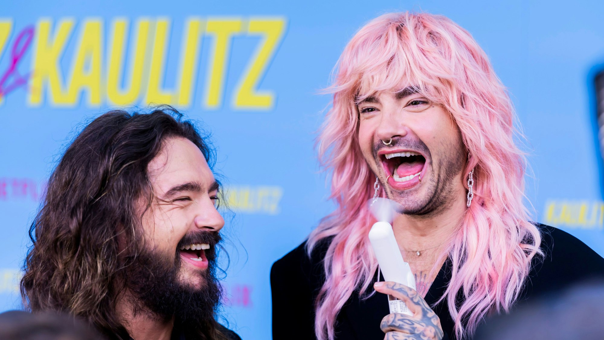 Die Zwillingsbrüder Bill (r) und Tom Kaulitz lachen auf dem Roten Teppich zur Netflix-Dokuserie „Kaulitz & Kaulitz“.