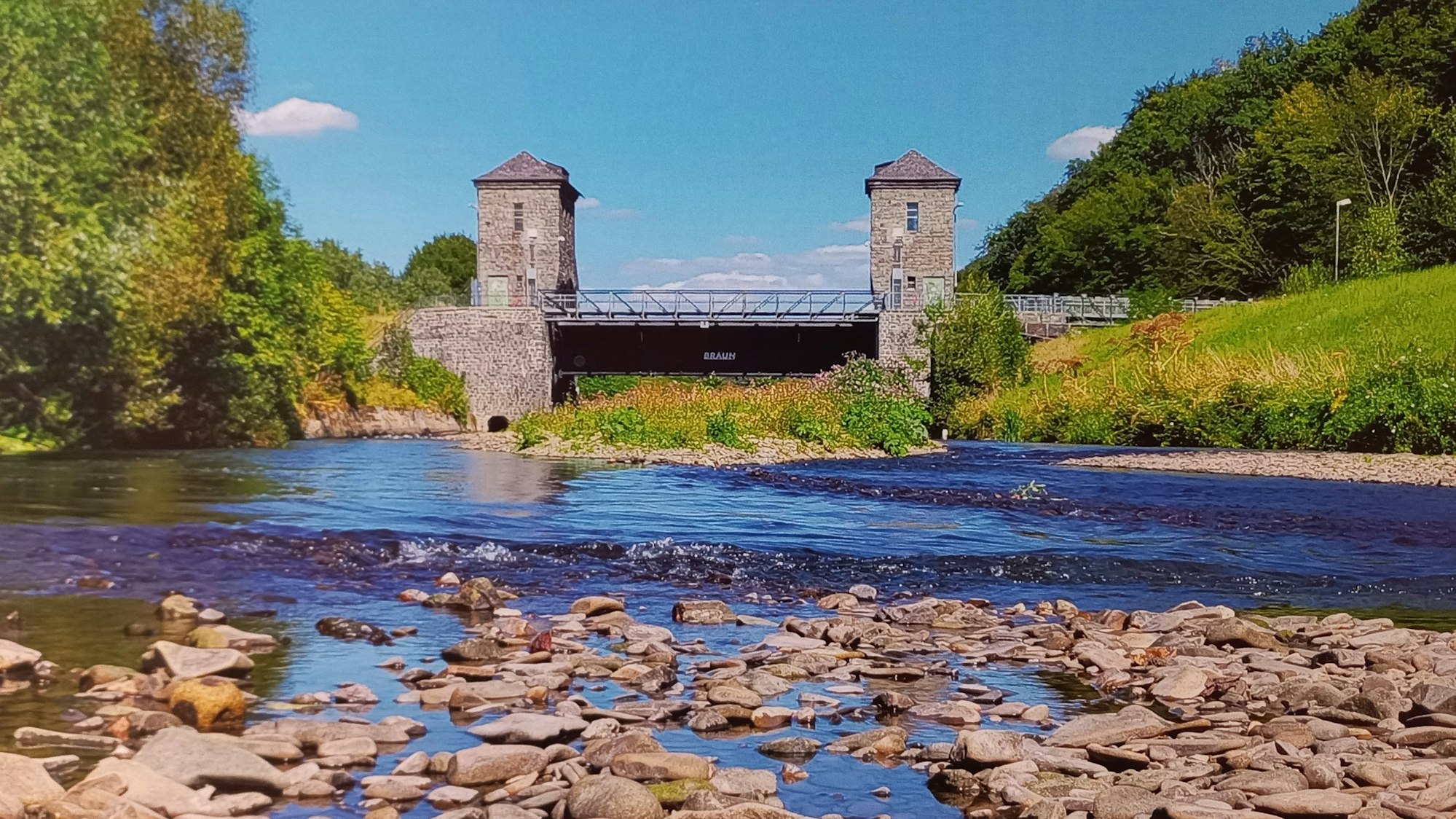 Zu sehen ist ein Wasserwehr an der Agger.