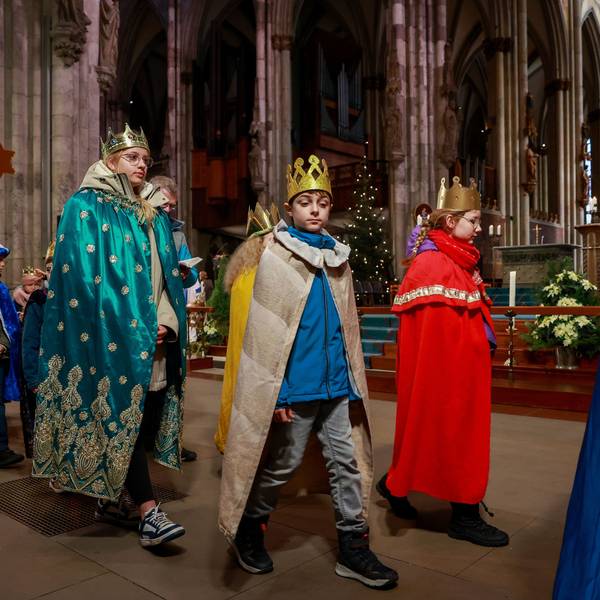 Kinder verkleidet als Heilige Drei Könige gehen durch den Kölner Dom.