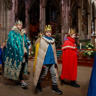 Kinder verkleidet als Heilige Drei Könige gehen durch den Kölner Dom.