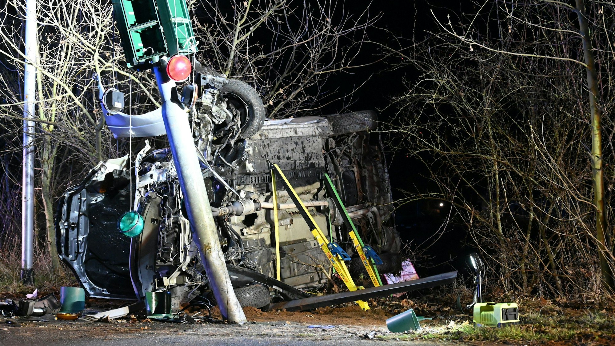 Ein zerstörtes Auto liegt an einer Ampel auf der Seite.