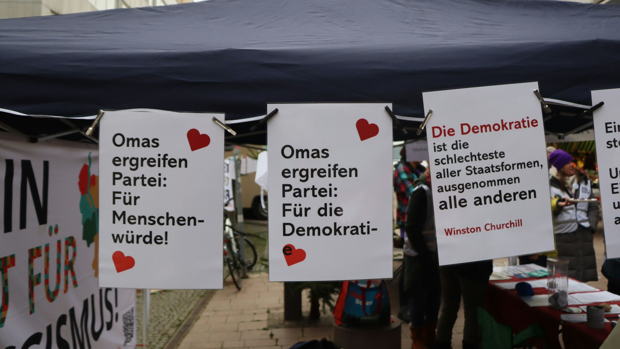 Das Foto zeigt aufgehängte Plakate an einem Infostand.