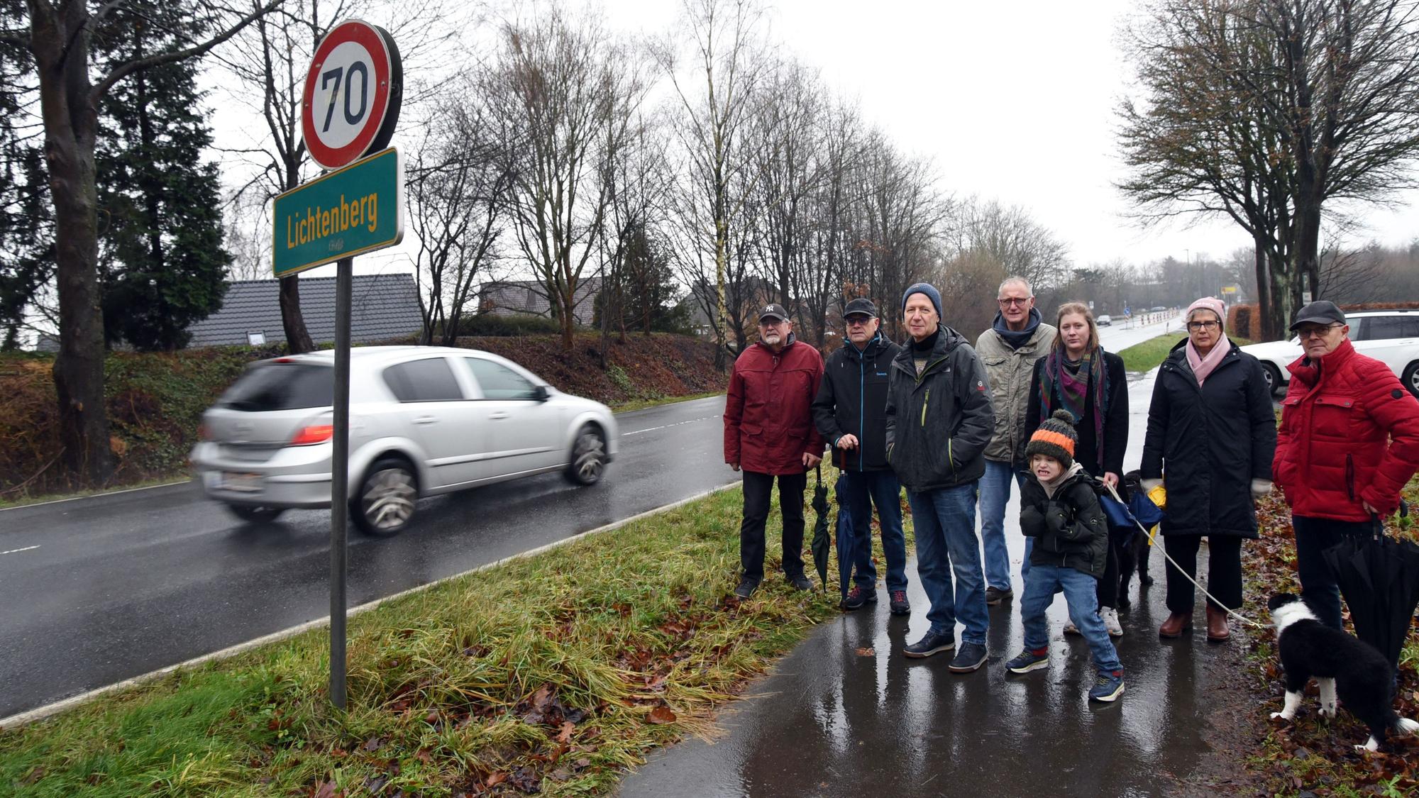 Auf weiten Teilen der Landesstraße 324 in Morsbach-Lichtenberg soll Tempo 70 gelten, damit der Verkehr auf der stark befahrenen Straße weniger Lärm macht. Das fordern Johannes Schlechtingen (3. von links) und seine Mitstreiter jetzt in einer Petition für ihren Wohnort. Unser Foto zeigt die Gruppe am Straßenrand