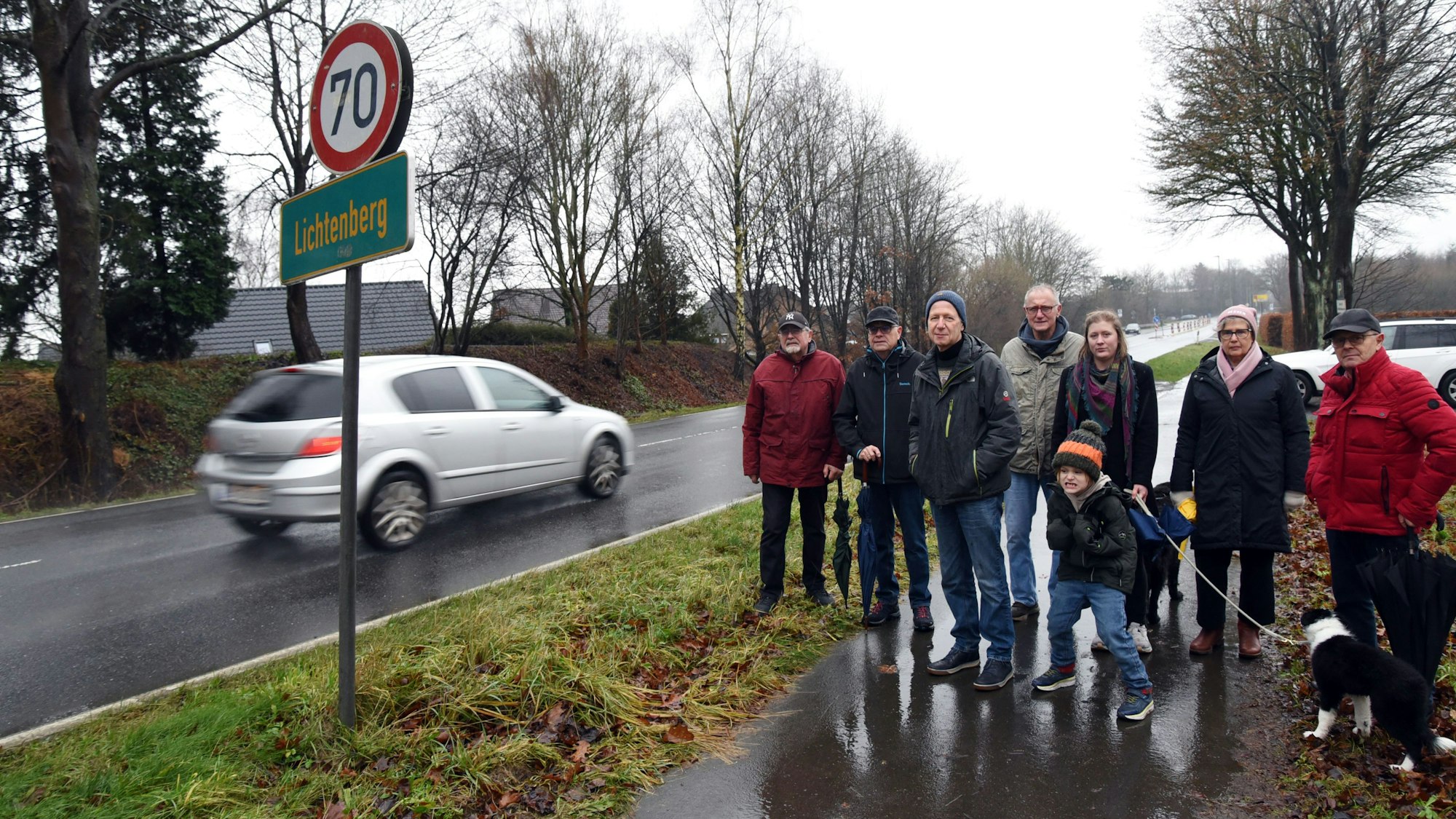 Auf weiten Teilen der Landesstraße 324 in Morsbach-Lichtenberg soll Tempo 70 gelten, damit der Verkehr auf der stark befahrenen Straße weniger Lärm macht. Das fordern Johannes Schlechtingen (3. von links) und seine Mitstreiter jetzt in einer Petition für ihren Wohnort. Unser Foto zeigt die Gruppe am Straßenrand