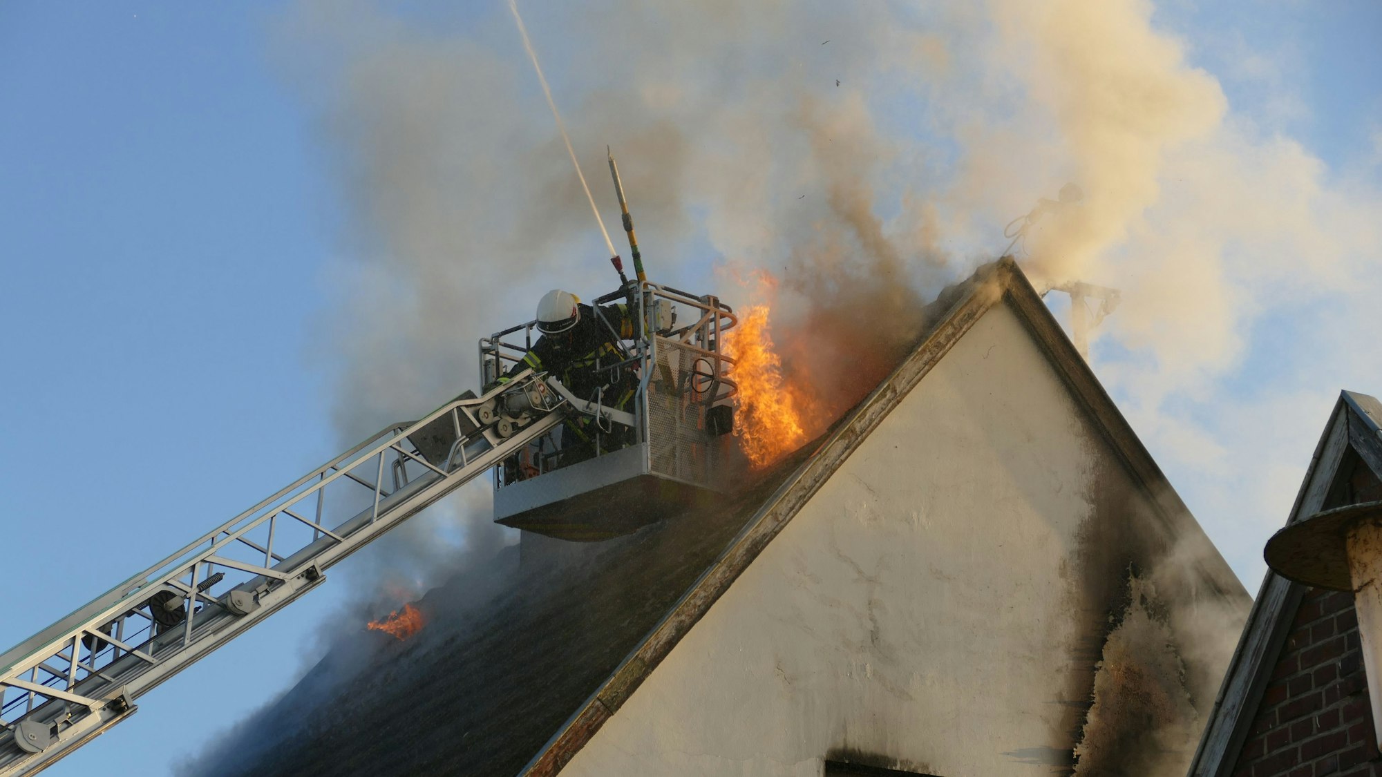 Flammen schlagen aus dem Dachstuhl des Hauses.