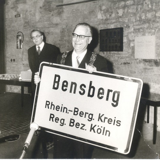 Bürgermeister Müller-Frank mit Ortsschild Bensberg in der letzten Ratssitzung des Rates der Stadt Bensberg im Ratssaal in Bensberg 18. Dezember 1974.