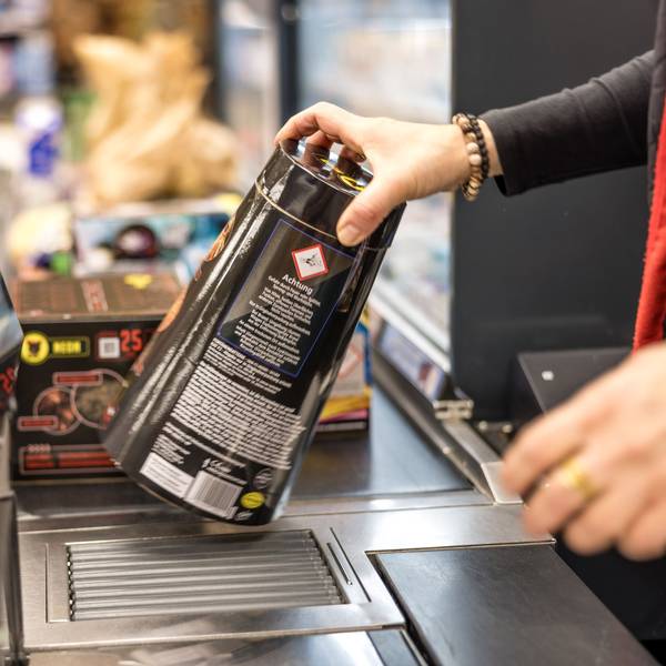 An der Kasse eines Supermarktes wird Feuerwerk über das Band gezogen und gescannt.