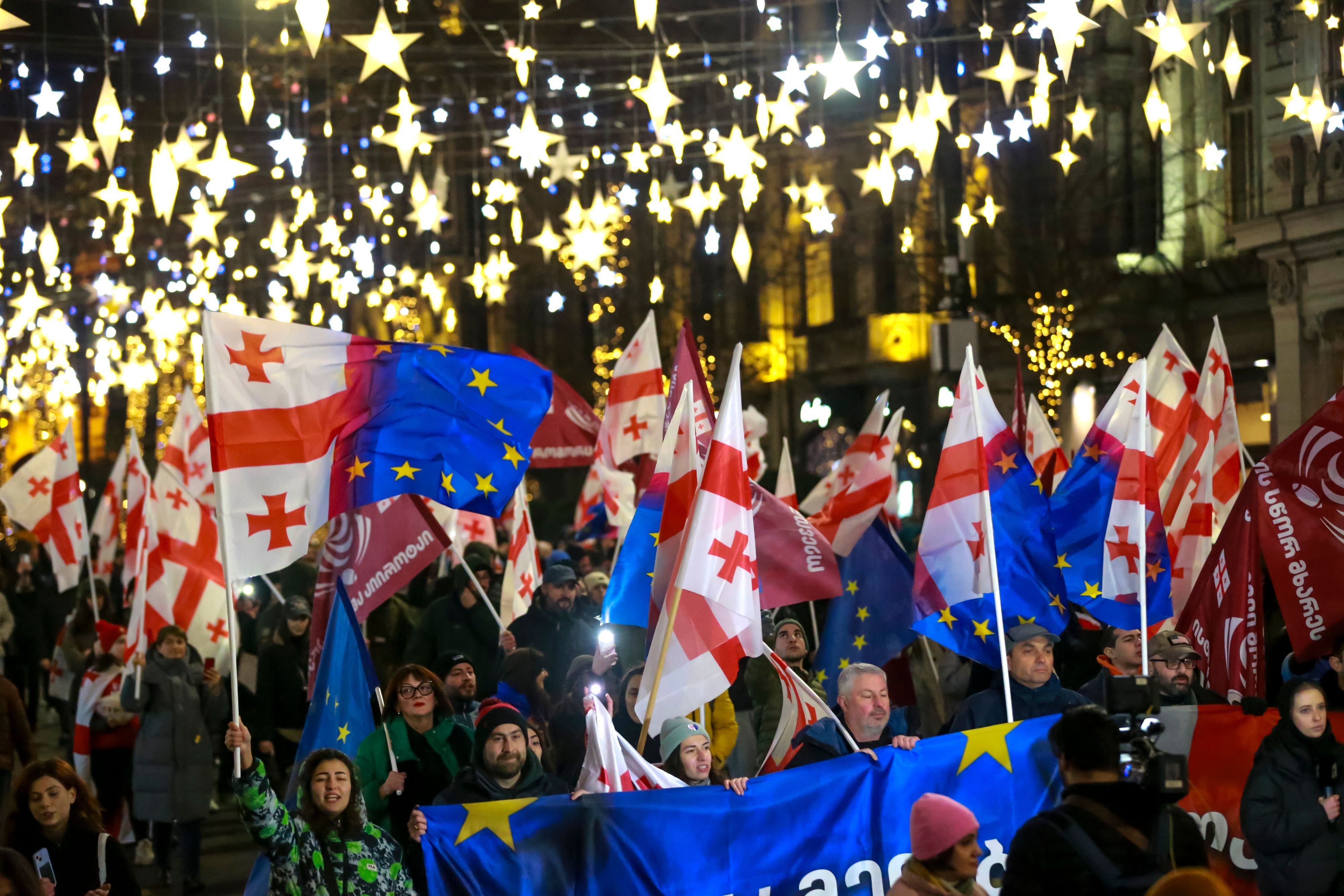 dpatopbilder - 28.12.2024, Georgien, Tiflis: Demonstranten mit georgischen National- und EU-Fahnen nehmen an einer regierungskritischen Kundgebung vor dem Parlamentsgebäude teil.